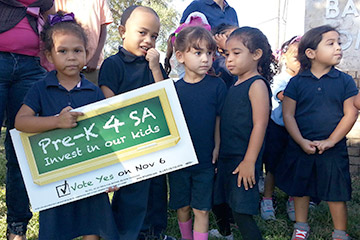 5 young students hold a sign that says "Pre-K 4 SA, Invest in our kids"
