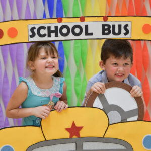 children play in a cardboard school bus pop up