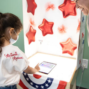 child voting at a booth with stripes and stars