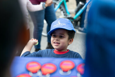 a young boy wears a Pre K 4 SA ballcap and smiles