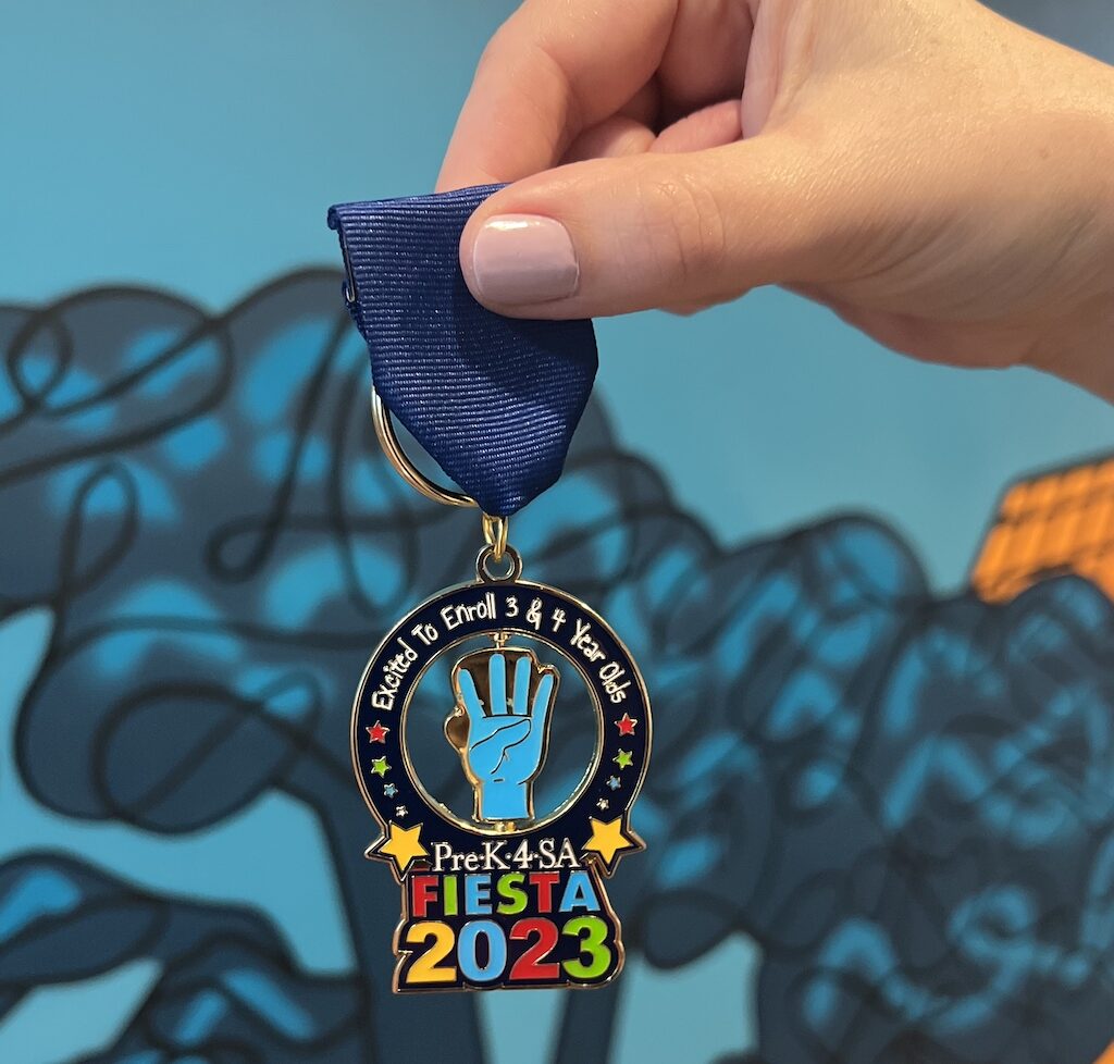 a hand holds a Pre-K 4 SA Fiesta medal