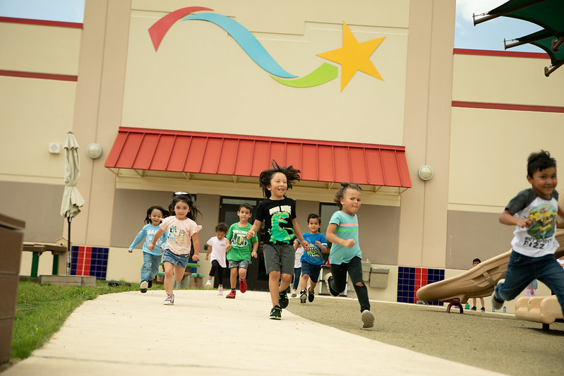 young children run outside in the sun