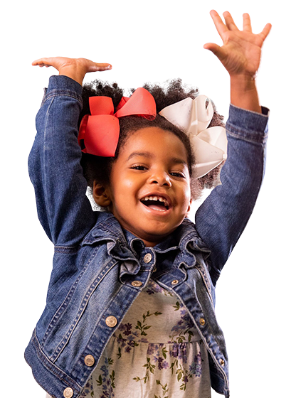 a young girl with pink bows on her head reaches her hands up at the sky