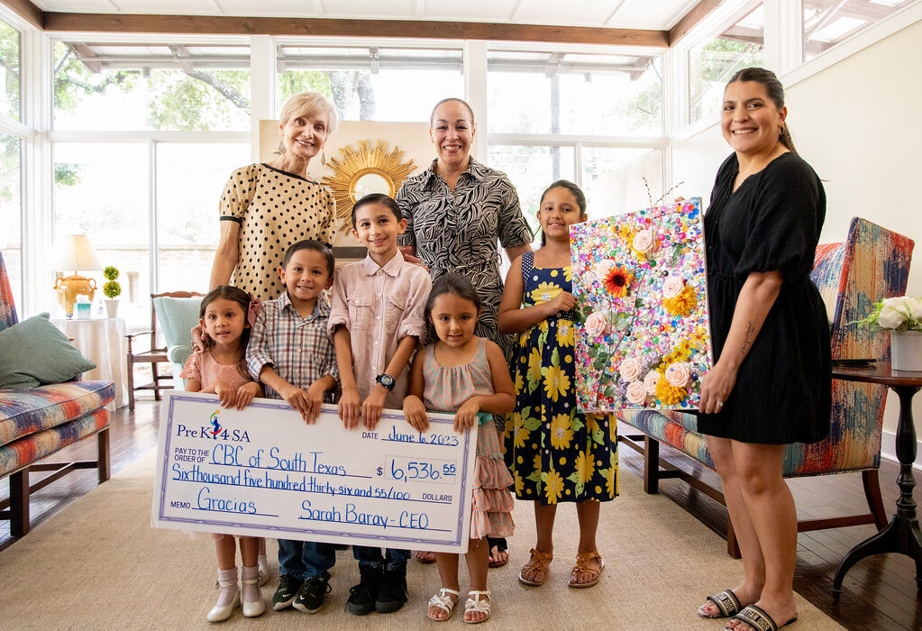 a group of Pre-K 4 SA children present a check worth $6536.55