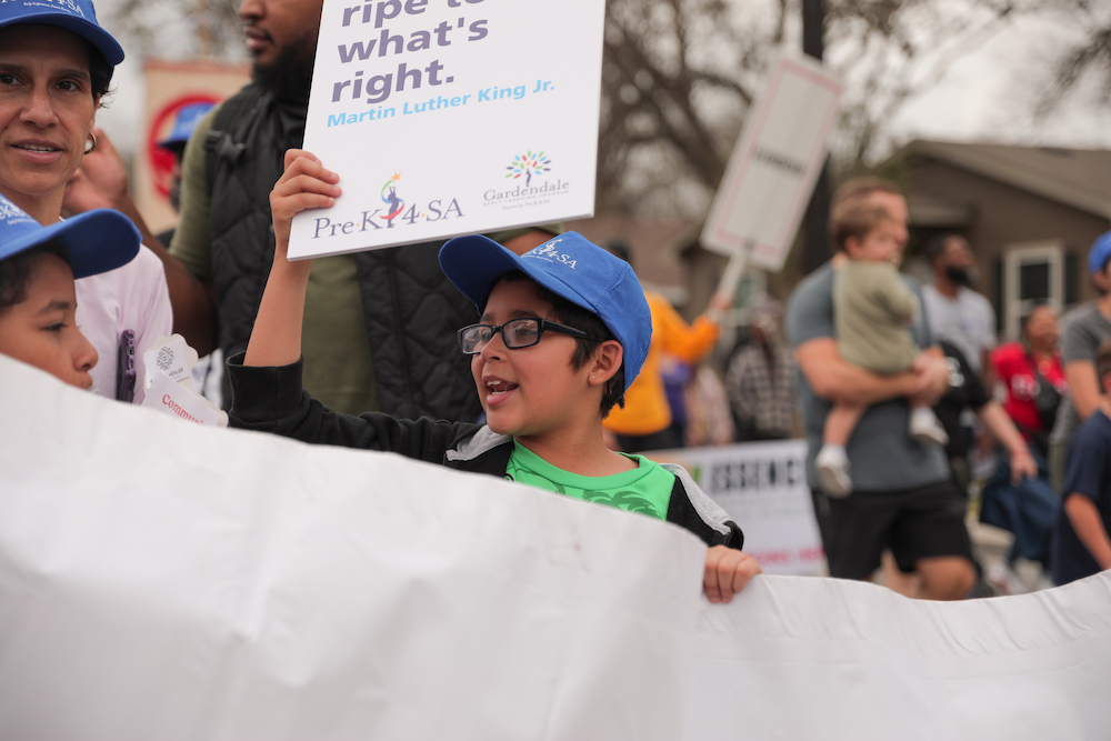 Children and community take part in an outdoor march for Martin Luther King Junior Day in San Antonio
