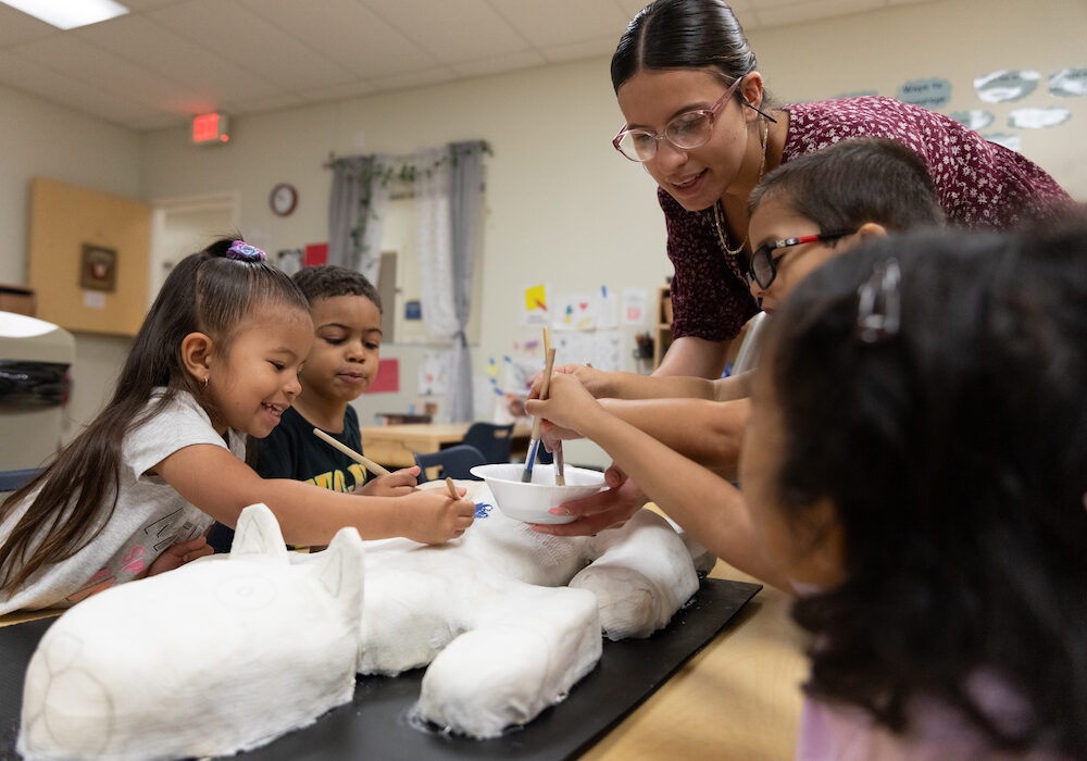 Educators and children build a sculpture in a classroom