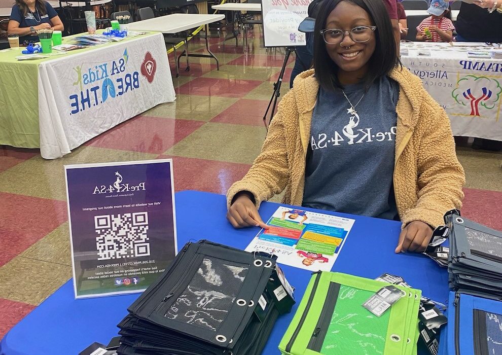 Pre-K 4 SA intern tabling and smiling at an event.