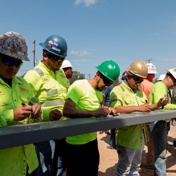 Construction workers sign a beam while working on the Pre-K 4 SA South build.