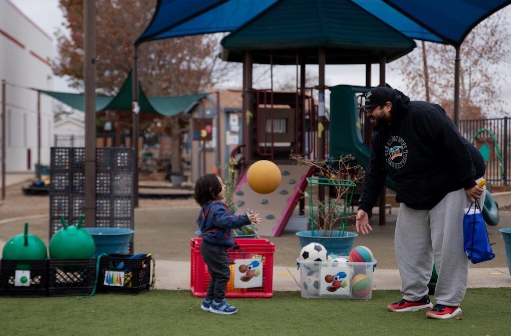 A child plays with a toy ball in a playground