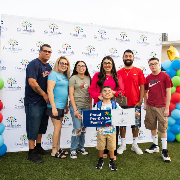 proud pre-k 4 sa family A family poses for a photo in front of balloons and a sign