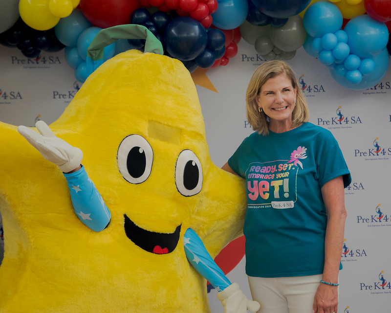Rockstar preschool mascot with woman at Pre-K 4 SA event