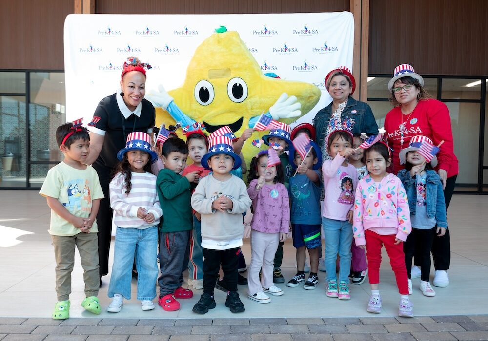 Stars mascot celebrating with diverse preschool children and teachers during patriotic event at Pre-K 4 SA in San Antonio, Texas.