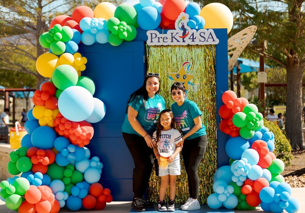 a family poses for a photo in front of a blue pre k 4 sa door