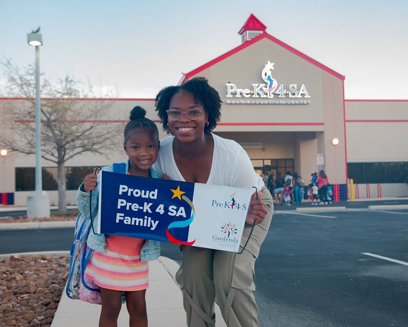 Happy children outside Pre-K 4 SA school with parent, promoting early childhood education.