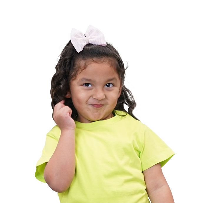 Happy young girl with curly hair and white bow in yellow shirt, preschool student.