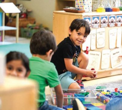 Young children playing with educational toys in a preschool classroom.