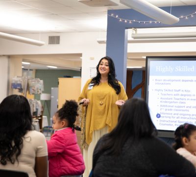 A woman giving a presentation to a group of children