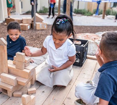 young children play with building blocks outside