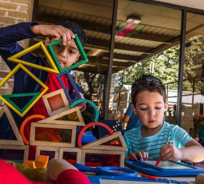 young boys play with building blocks and etch-a-sketch